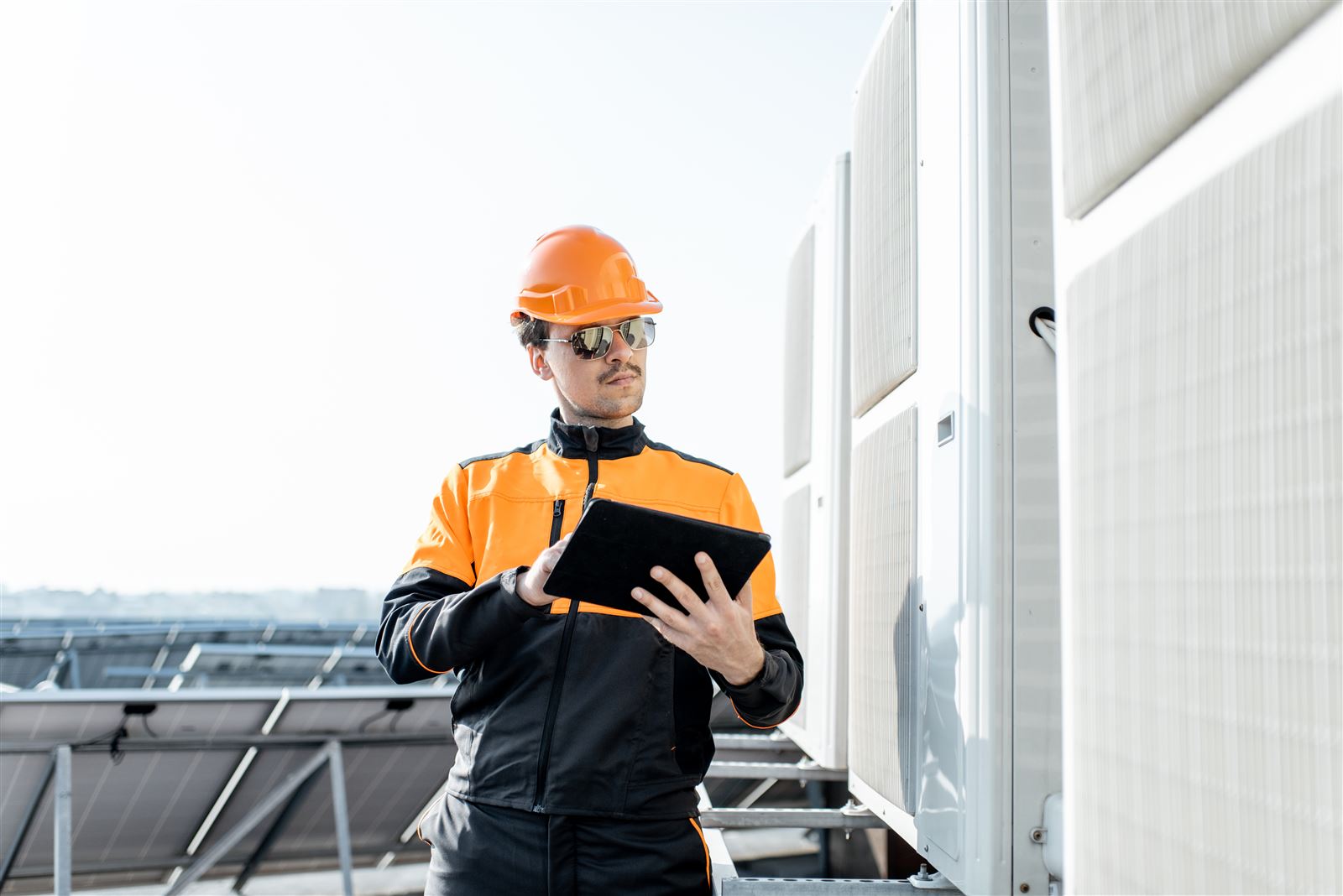 Field service technician using a tablet beside outdoor equipment